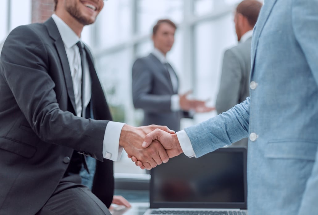 happy young businessman shaking hands with his business partner